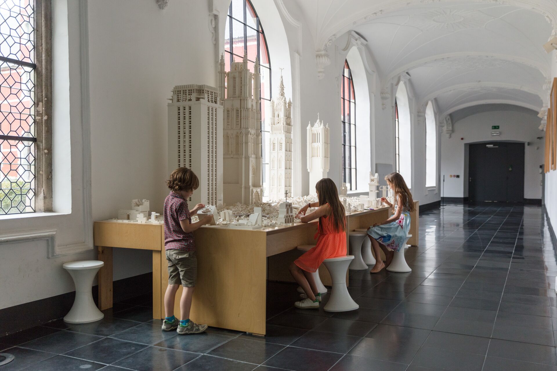 3 kinderen zijn bezig met het ontwerpen van bouwwerkjes in een interactief deel van het STAM-museum.