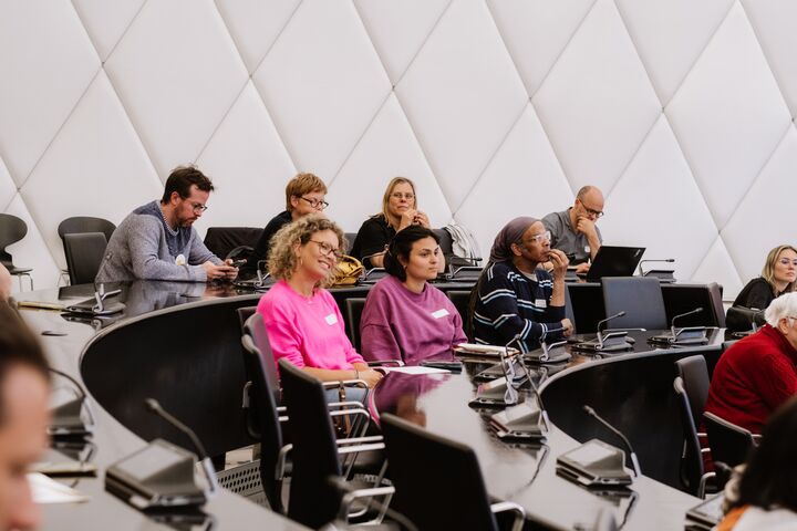 Mensen volgen een lezing in een zaal tijdens het congres Rap op Stap van het initiatief Iedereen Verdient Vakantie.