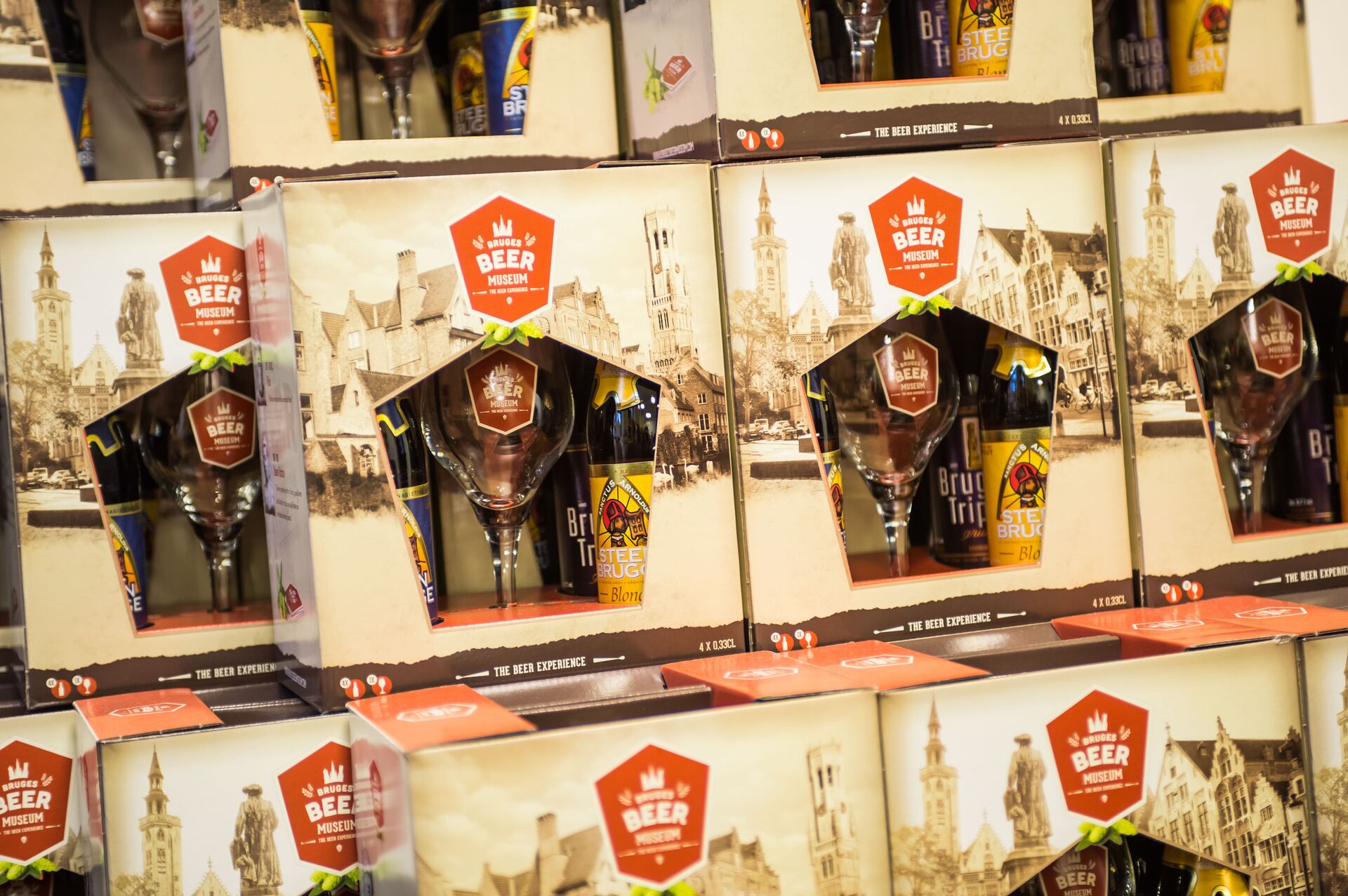 Gift sets with beer glass and bottles at Bruges beer museum Stacked gift packs with beer glass and bottles on a shop shelf at the Beer Museum.