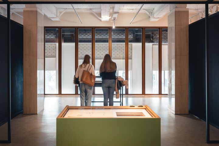 2 mensen kijken naar een expositie in een museum.