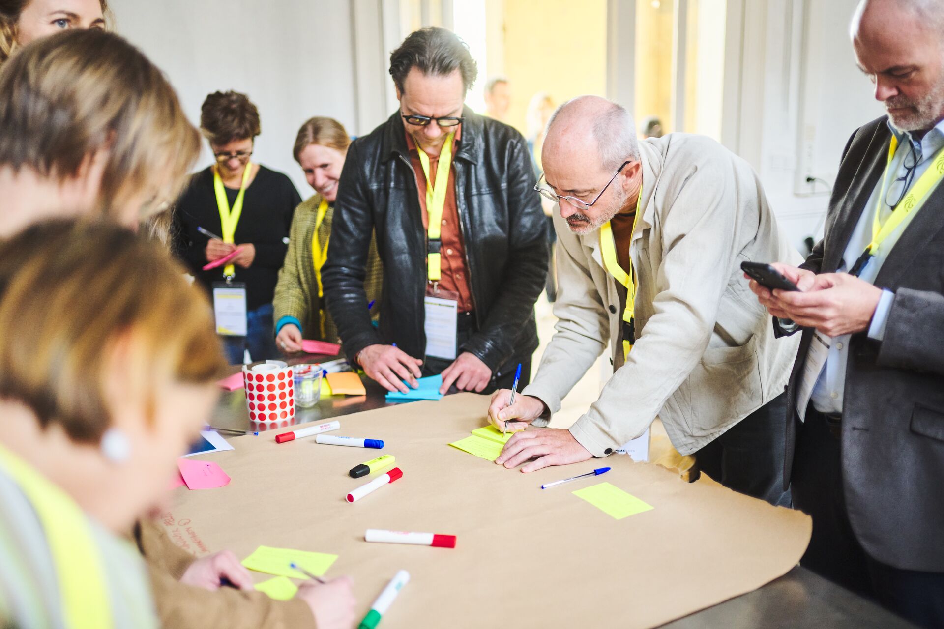 Een groep  mensen schrijft op sticky notes tijdens een bezoek aan het culinair belevingscentrum de Smaakhaven.