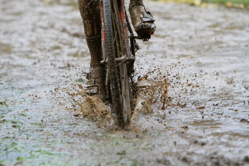 Front view of cyclist riding through puddle 