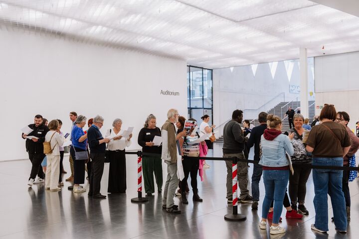 Een groep medewerkers staat te wachten voor een auditorium tijdens het Rap op Stap-congres.