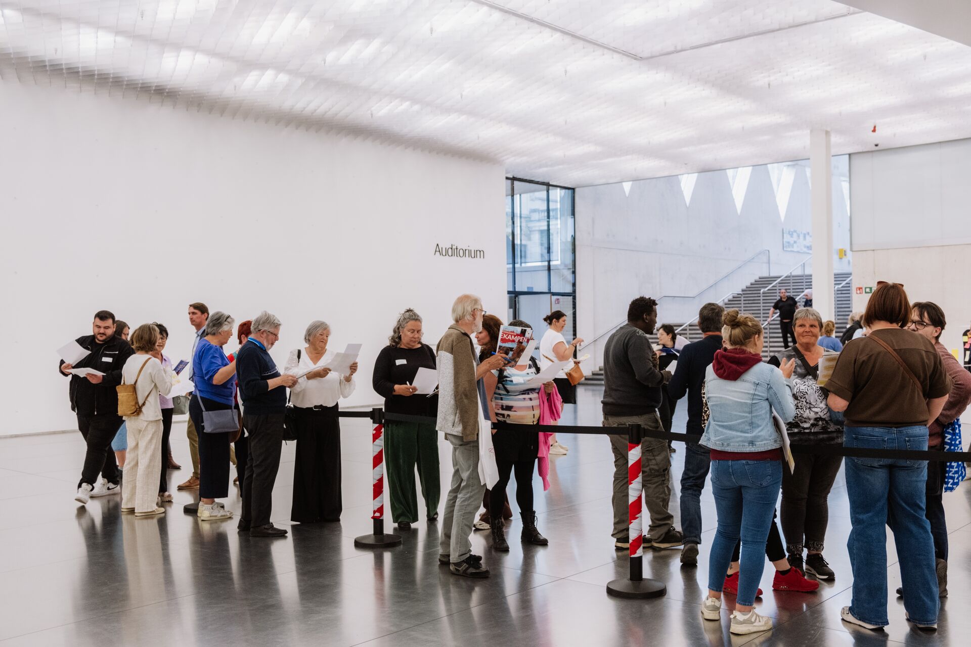 Een groep medewerkers staat te wachten voor een auditorium tijdens het Rap op Stap-congres.