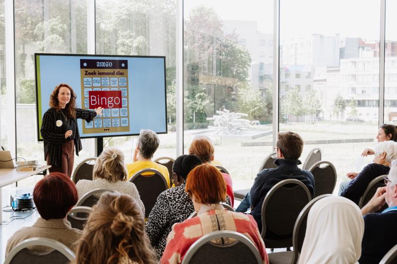 vrouw die voor publiek staat en presentatie geeft