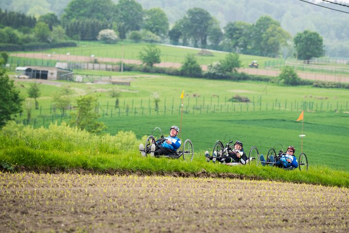 Handbikers cycling in a rural landscape in Flanders